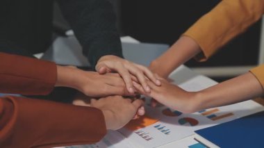 İş adamları el ele tutuşuyor. Tablolar ve grafikler masada. Takım çalışması konsepti. 
