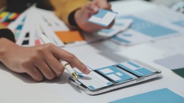 Yeni bir uygulama üzerinde çalışan arayüz tasarımcılarından oluşan bir ekip, prototip modelleri çalışma alanlarına yayılmış durumda.