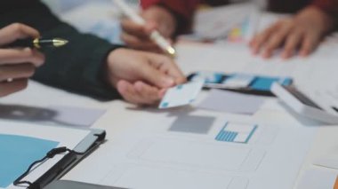 UX ya da UI tasarımcılarından oluşan bir grup masadaki modelleme prototiplerine sahip yeni bir uygulama tasarlıyor
