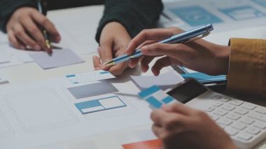 UX ya da UI tasarımcılarından oluşan bir grup masadaki modelleme prototiplerine sahip yeni bir uygulama tasarlıyor