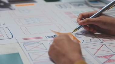 UX ya da UI tasarımcılarından oluşan bir grup masadaki modelleme prototiplerine sahip yeni bir uygulama tasarlıyor