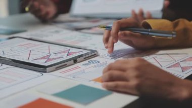 UX ya da UI tasarımcılarından oluşan bir grup masadaki modelleme prototiplerine sahip yeni bir uygulama tasarlıyor