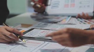 UX ya da UI tasarımcılarından oluşan bir grup masadaki modelleme prototiplerine sahip yeni bir uygulama tasarlıyor