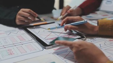 UX ya da UI tasarımcılarından oluşan bir grup masadaki modelleme prototiplerine sahip yeni bir uygulama tasarlıyor