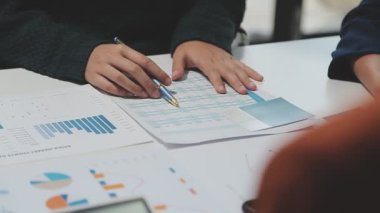 Görsel raporlarla çevrili, çağdaş çalışma alanındaki finansal verileri analiz eden profesyoneller