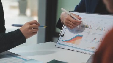 Görsel raporlarla çevrili, çağdaş çalışma alanındaki finansal verileri analiz eden profesyoneller