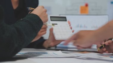 Görsel raporlarla çevrili, çağdaş çalışma alanındaki finansal verileri analiz eden profesyoneller