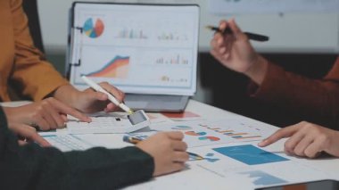 Görsel raporlarla çevrili, çağdaş çalışma alanındaki finansal verileri analiz eden profesyoneller