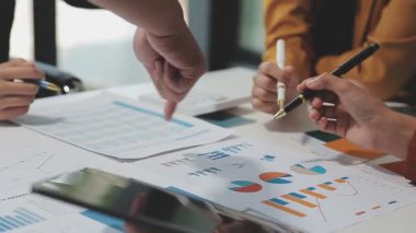 Görsel raporlarla çevrili, çağdaş çalışma alanındaki finansal verileri analiz eden profesyoneller