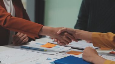 Çağdaş çalışma alanında finansal verileri analiz eden bir grup profesyonel iş adamı, görsel raporlarla çevrili