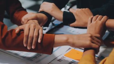 İş adamları el ele tutuşuyor. Tablolar ve grafikler masada. Takım çalışması konsepti. 