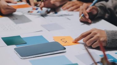 Yeni mobil uygulama ve web sitesi için renkli UX modelleri ve prototipleriyle çalışan tasarımcı takımı