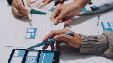 Yeni mobil uygulama ve web sitesi için renkli UX modelleri ve prototipleriyle çalışan tasarımcı takımı