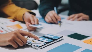 Yeni mobil uygulama ve web sitesi için renkli UX modelleri ve prototipleriyle çalışan tasarımcı takımı