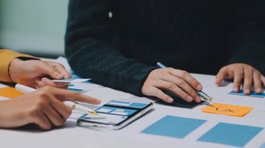 Yeni mobil uygulama ve web sitesi için renkli UX modelleri ve prototipleriyle çalışan tasarımcı takımı