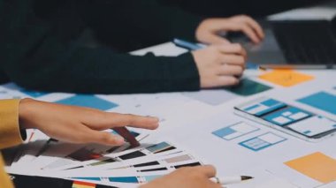 Yeni mobil uygulama ve web sitesi için renkli UX modelleri ve prototipleriyle çalışan tasarımcı takımı