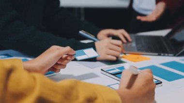 Yeni mobil uygulama ve web sitesi için renkli UX modelleri ve prototipleriyle çalışan tasarımcı takımı