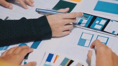 Yeni mobil uygulama ve web sitesi için renkli UX modelleri ve prototipleriyle çalışan tasarımcı takımı