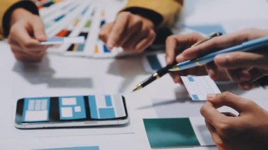 Yeni mobil uygulama ve web sitesi için renkli UX modelleri ve prototipleriyle çalışan tasarımcı takımı