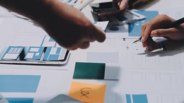 Yeni mobil uygulama ve web sitesi için renkli UX modelleri ve prototipleriyle çalışan tasarımcı takımı