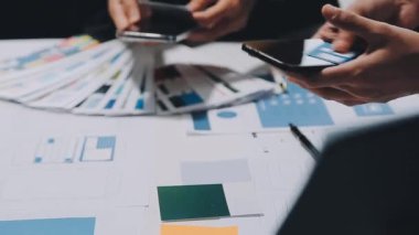 Yeni mobil uygulama ve web sitesi için renkli UX modelleri ve prototipleriyle çalışan tasarımcı takımı