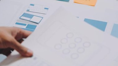 Yeni mobil uygulama ve web sitesi prototiplerinin renkli UX modellerini gösteren iş adamlarının yakın görüntüsü