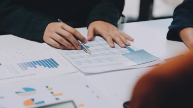 Modern ofiste grafikler ve çizelgeler ile çalışan bir grup iş adamı masa, finans ve yatırım konsepti üzerinde belgeler 