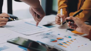 Modern ofiste grafikler ve çizelgeler ile çalışan bir grup iş adamı masa, finans ve yatırım konsepti üzerinde belgeler 