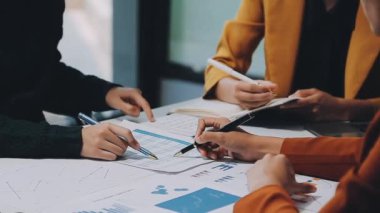 Modern ofiste grafikler ve çizelgeler ile çalışan bir grup iş adamı masa, finans ve yatırım konsepti üzerinde belgeler 