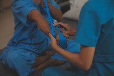 Profesyonel fizyoterapist genç bir adamı muayene eder ve tedavi eder. Hastanedeki bir adamın kaslarını ve yaralarını tedavi eder..