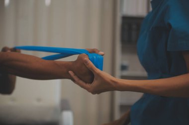 Profesyonel fizyoterapist genç bir adamı muayene eder ve tedavi eder. Hastanedeki bir adamın kaslarını ve yaralarını tedavi eder..