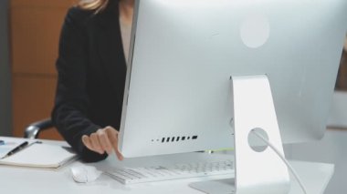 Bilgisayarda çalışan ve dizüstü bilgisayarda yazan iş kadını.