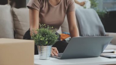 Genç kadın ofiste dizüstü bilgisayar kullanıyor.