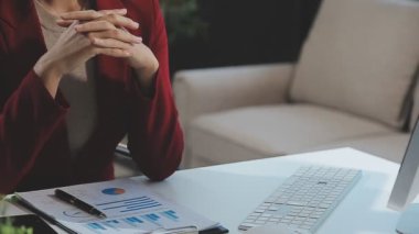 Genç bayan ofiste oturuyor ve tablet kullanıyor.