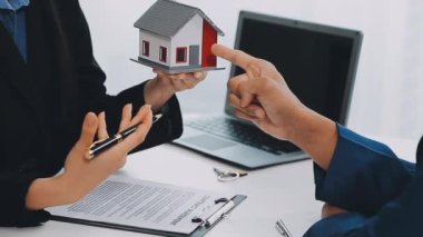 İş adamı ve ev modeli evin anahtarlarını tutuyor.