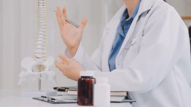 Doktor iskelet modeli tutuyor.