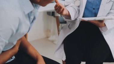 Masada oturan üniformalı ve tıbbi giysili genç bayan doktor.