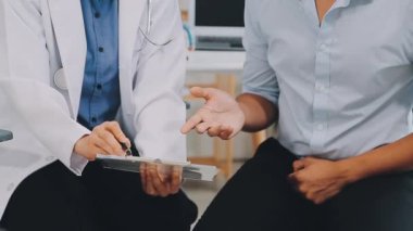 Doktor ve hasta hastanede masada otururken bir şey tartışıyorlar. Sağlık ve Tıp Konsepti