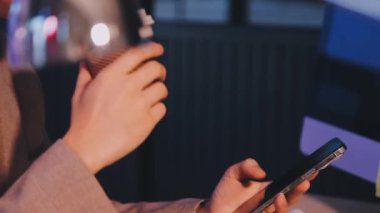 Kafede otururken akıllı telefon kullanan bir işadamı..