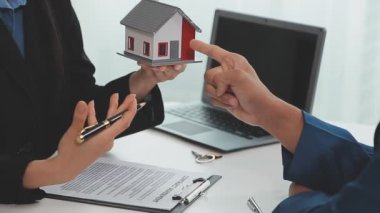 Emlakçı kontrat imzaladıktan sonra model ev ile tokalaşıyor