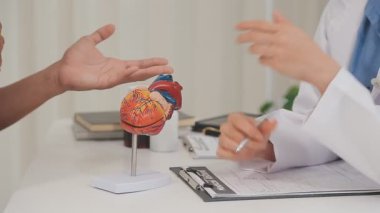 İş yerinde kardiyogramı inceleyen erkek doktor, yakın plan.