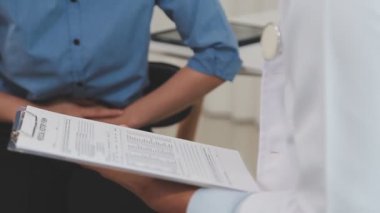 Doktor muayenehanedeki hastaya reçete yazıyor. Kapatın.