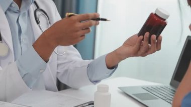 Doktor ilaç alırken dizüstü bilgisayar kullanıyor