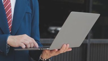 Açık havada dizüstü bilgisayar kullanan iş adamı