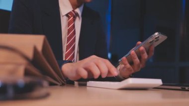 Akıllı telefon kullanan ve kredi kartı tutan bir iş adamı.