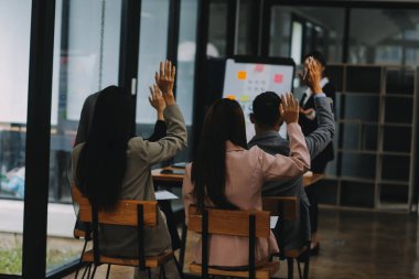 Genç Asyalı iş adamlarından oluşan bir grup ofiste fikir alışverişinde bulundu..