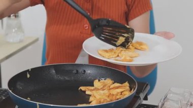 Asyalı kadın kızarmış patates pişiriyor.