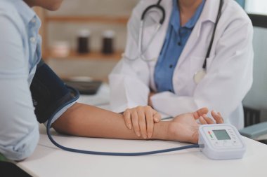 Doktor kadın nabız sayacını hastanın basıncını ölçmek için kullanıyor. Tıbbi kontrol konsepti..