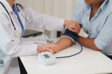 Doktor kadın nabız sayacını hastanın basıncını ölçmek için kullanıyor. Tıbbi kontrol konsepti..