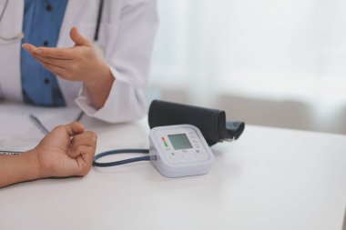 Doktor kadın nabız sayacını hastanın basıncını ölçmek için kullanıyor. Tıbbi kontrol konsepti..